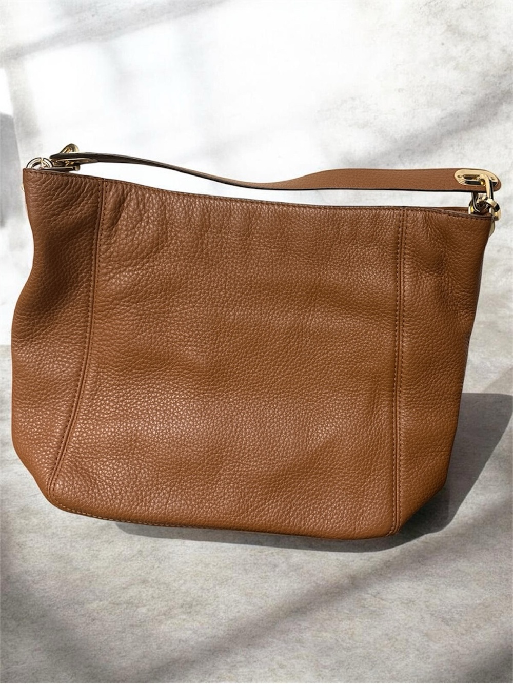 Michael Kors Cognac Pebbled Leather Shoulder Bag with Gold logo on the side.